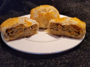 A sliced Knishes: Beef Brisket on a plate displaying its layered filling.