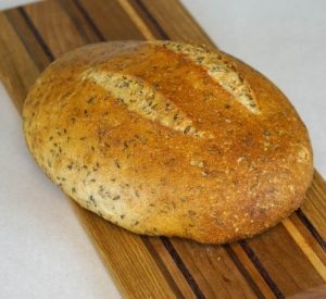 A loaf of bread on top of a wooden board.