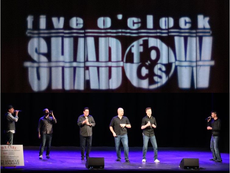 A group of men standing on stage with microphones.