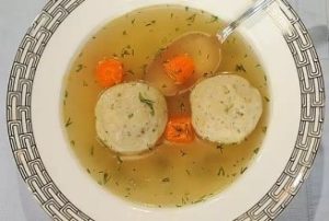 A bowl of soup with meat and vegetables.