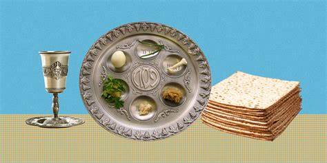 A passover seder plate with symbolic foods, next to a stack of matzo and a silver wine cup.