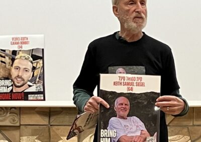 A man holding a poster appealing for the return of an individual named keith samuel siegel.