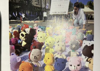 A collection of plush toys laid out on the ground at a public outdoor event.
