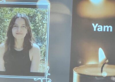 A projected image showing a framed photo of a woman next to the word "yam" and a lit candle.